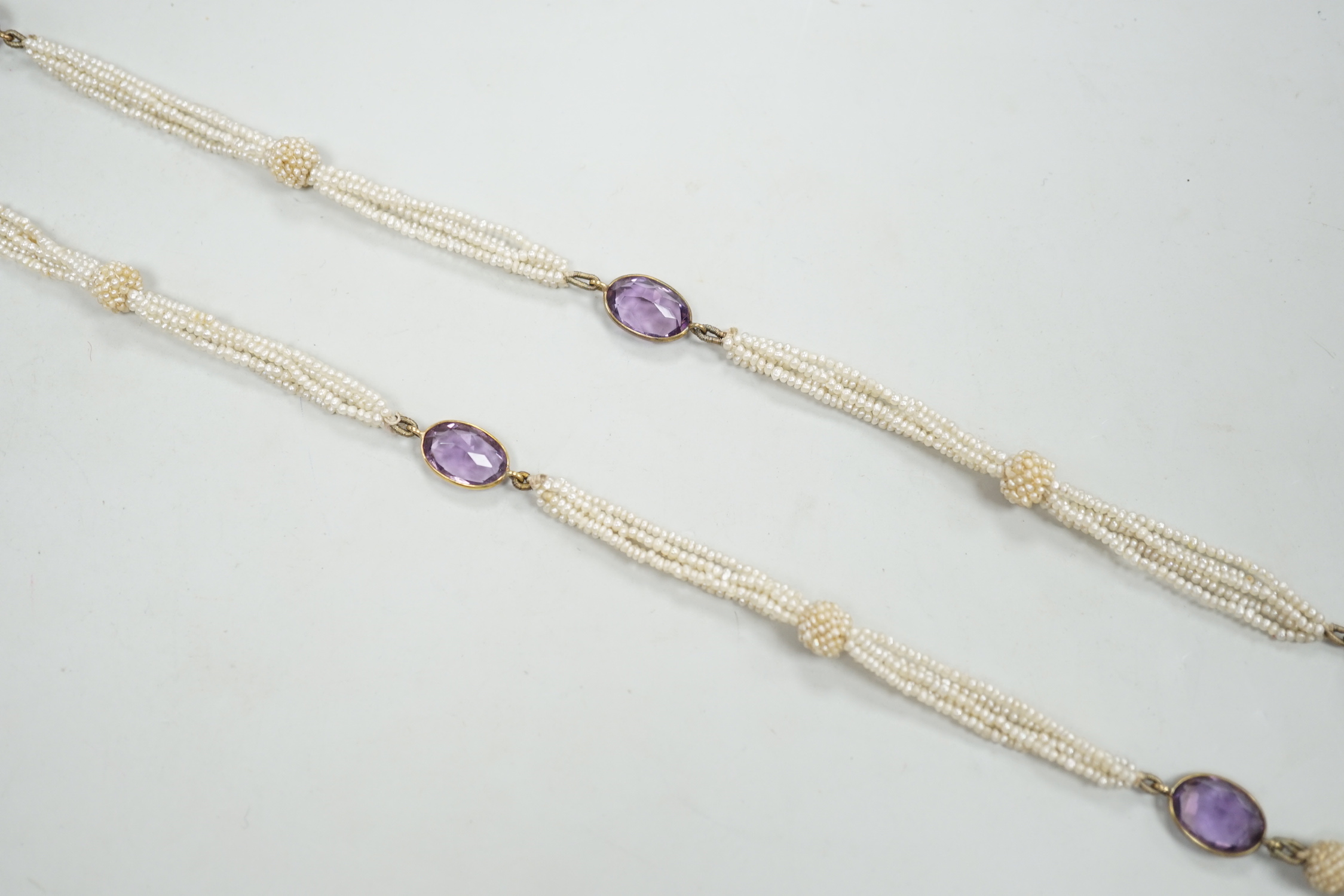 A 19th century Indian multi strand seed pearl and oval cut amethyst set long necklace, with gem set tassel drops, 166cm.